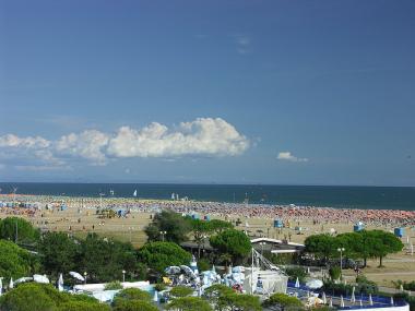 Písečná pláž se slunečníky v Bibione, Itálie